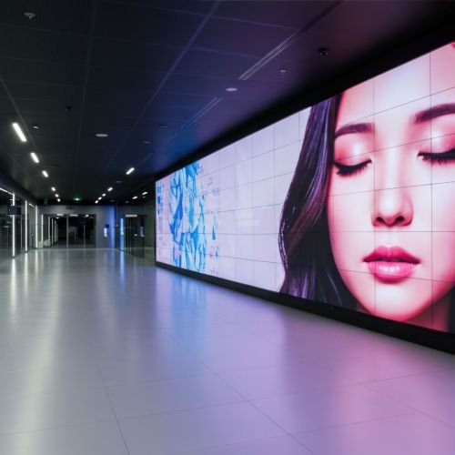 Modern interior space with large digital screen displaying woman face